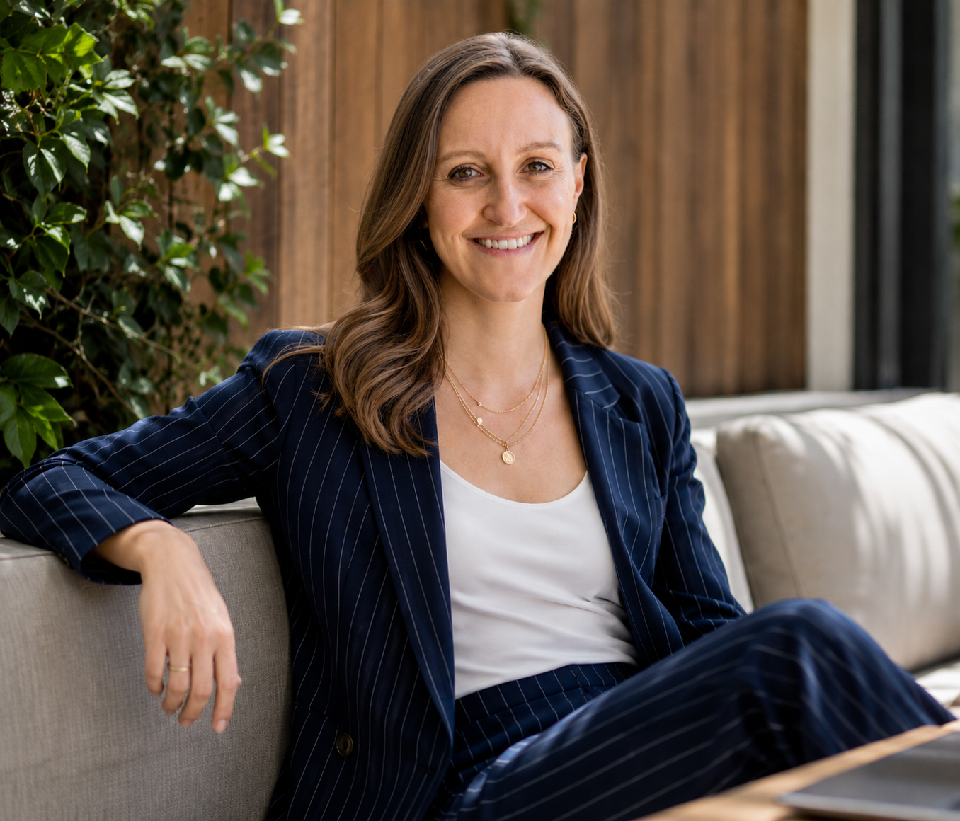 Jess, founder of JET Studio, smiling and seated in a navy pinstripe suit